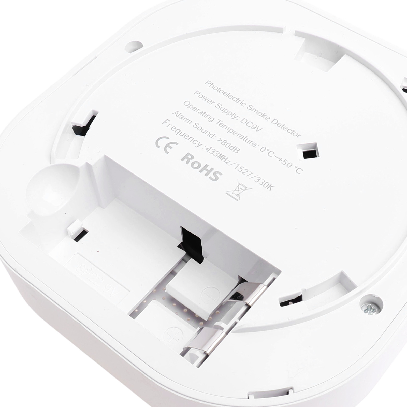 Rauchmelder mit Batteriefach, Beschriftung und Kontakten.