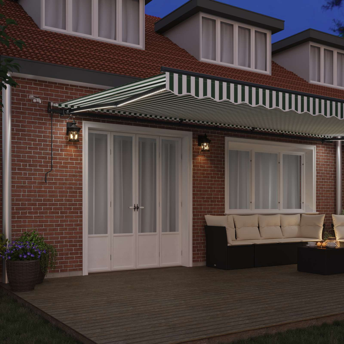 Una casa con toldo, luces, puertas, ventanas y muebles de patio por la noche.