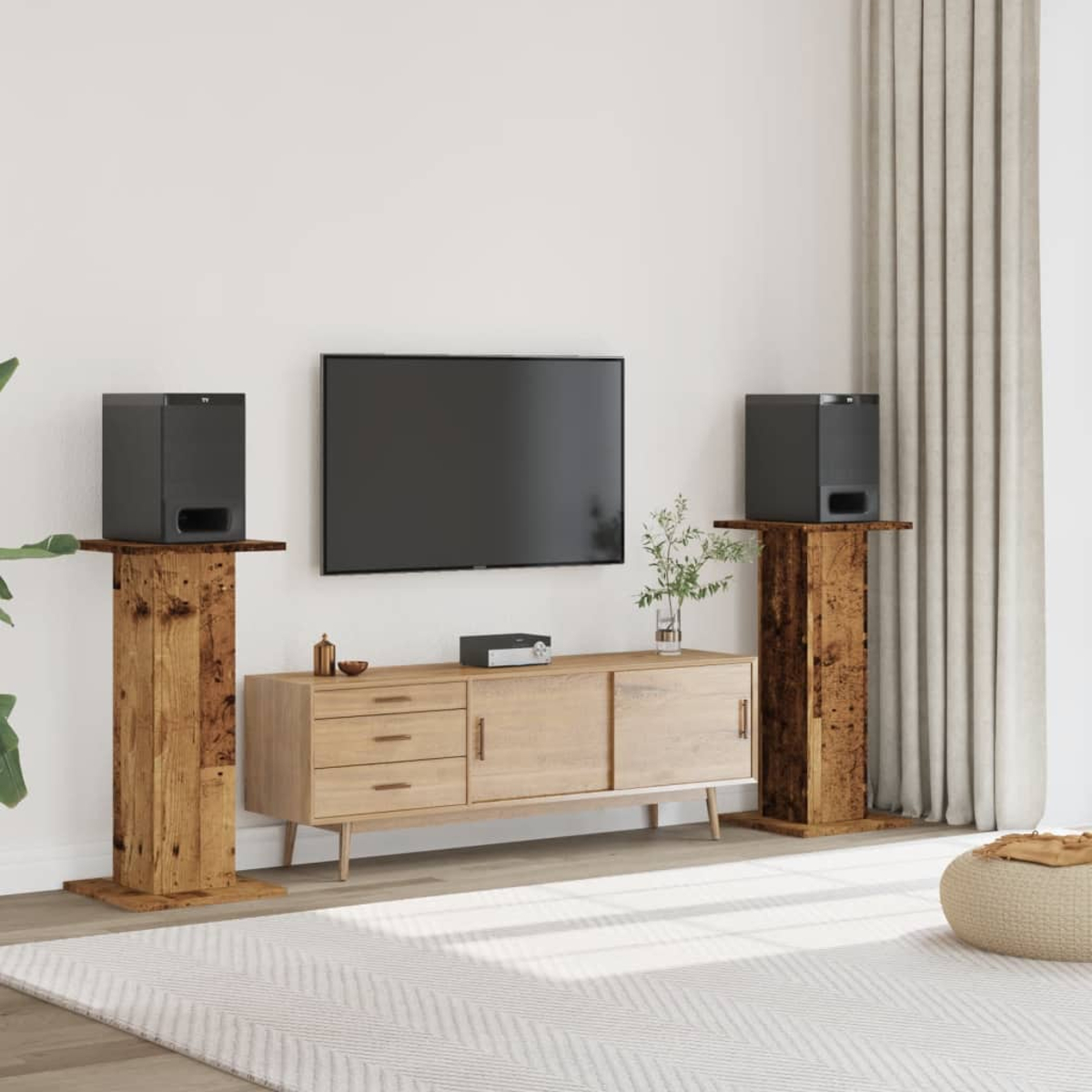 Ein Wohnzimmer mit Fernseher, Sideboard und zwei Lautsprecherständern.