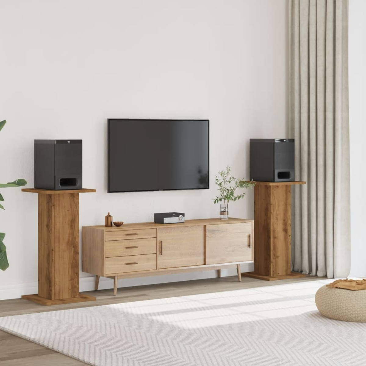 Ein Fernseher hängt über einem Holzsideboard, flankiert von zwei Lautsprechern auf Holzständern.