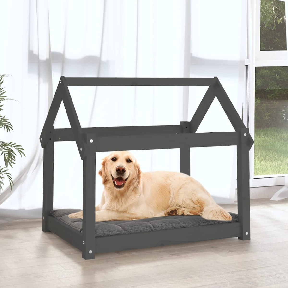 Ein Golden Retriever liegt auf einem grauen Hundebett in einem dunklen Holzhaus.