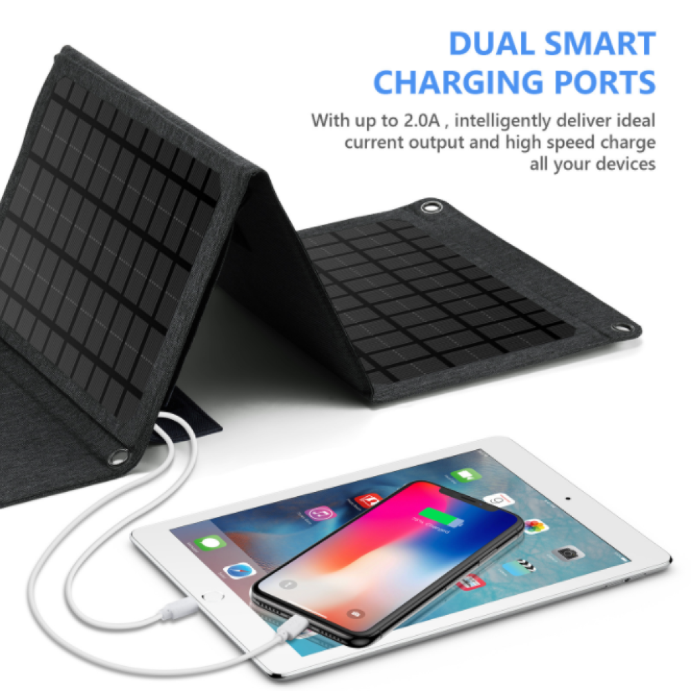 Ein faltbares Solarpanel lädt ein Tablet und ein Smartphone auf.