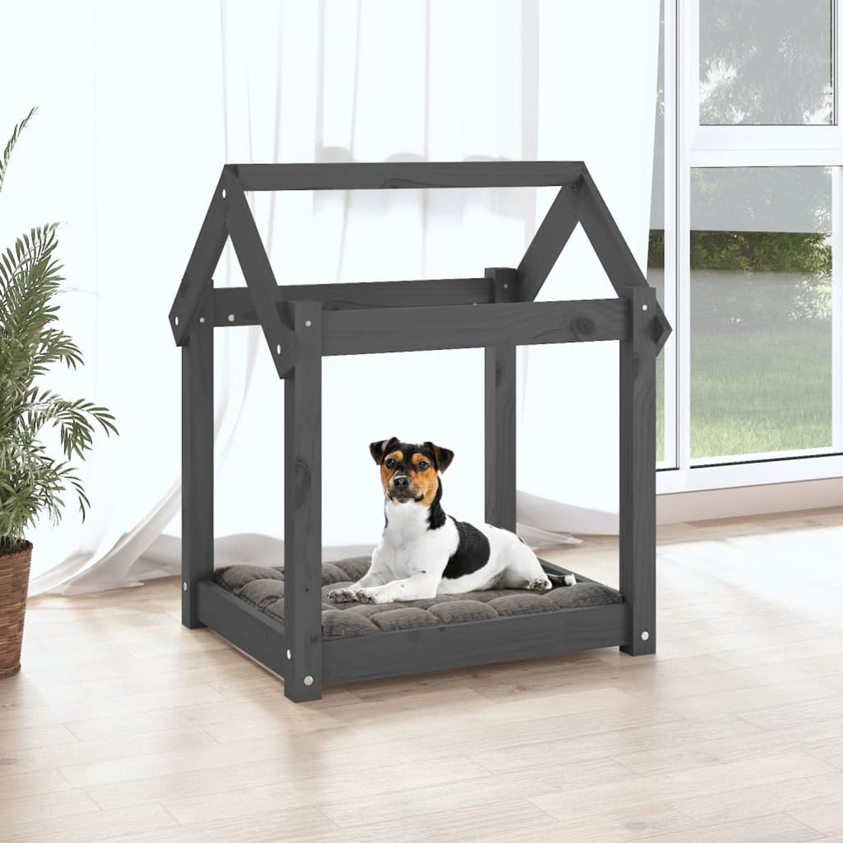 Ein Hund liegt auf einem Kissen in einem grauen Holzhaus für Haustiere.
