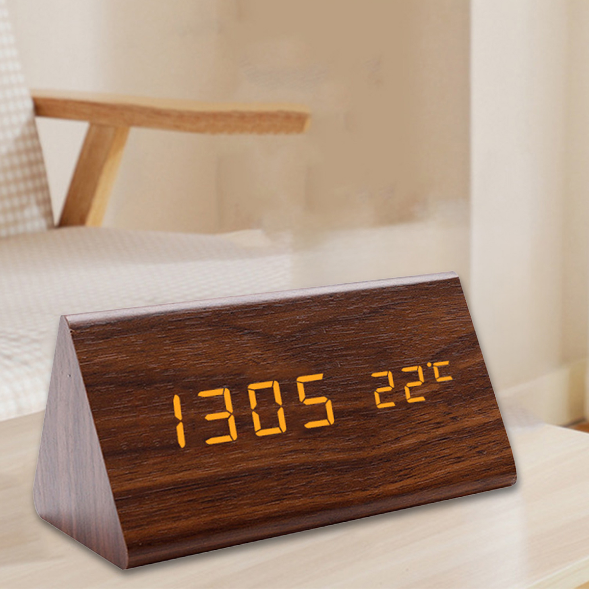 Eine hölzerne Digitaluhr zeigt 13:05 und 22C auf einem Tisch.