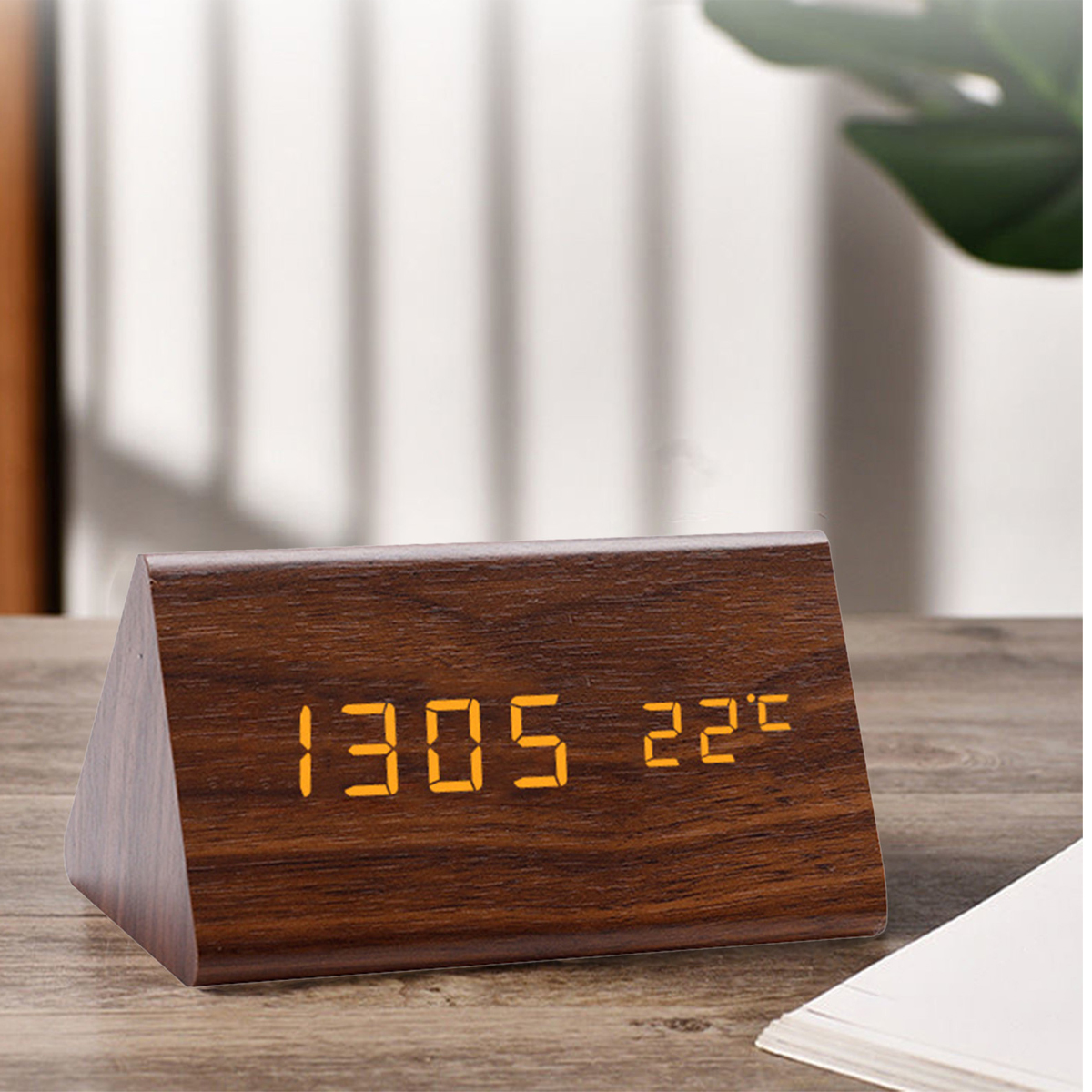 Holz-Digitaluhr zeigt 13:05 und 22°C an, mit hellem Hintergrund.