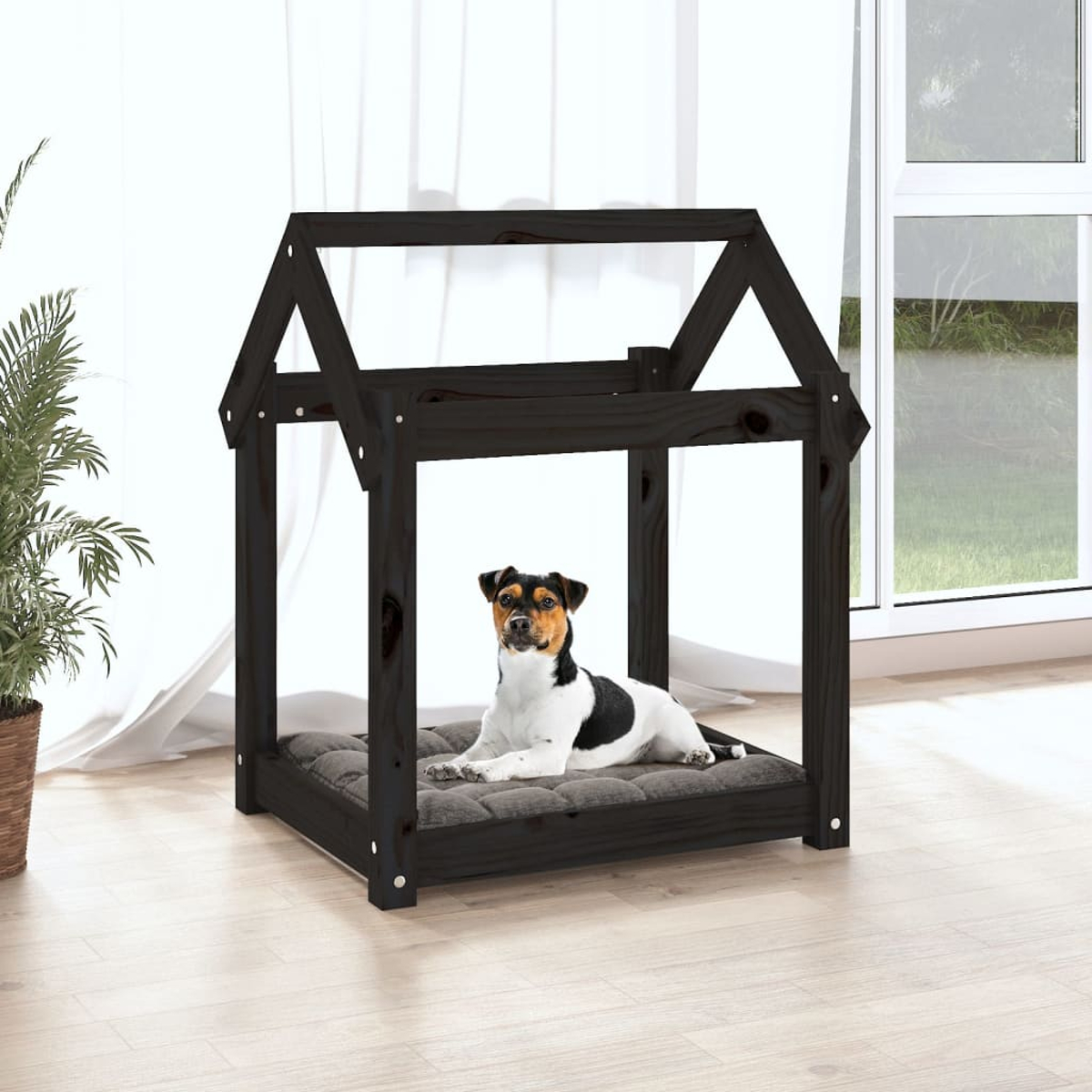 Ein Hund liegt auf einem Kissen in einem schwarzen Hundehaus.