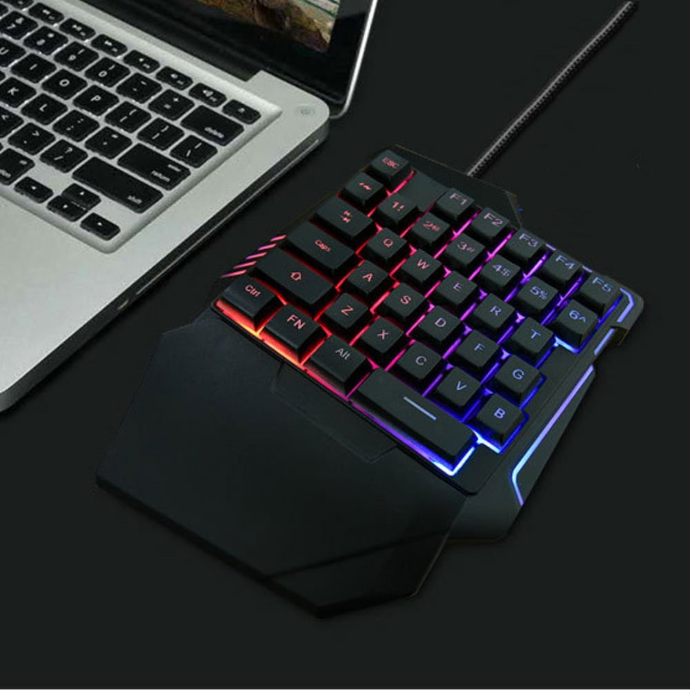 Ein Laptoptastatur neben einer RGB-Gaming-Tastatur auf dunklem Hintergrund.