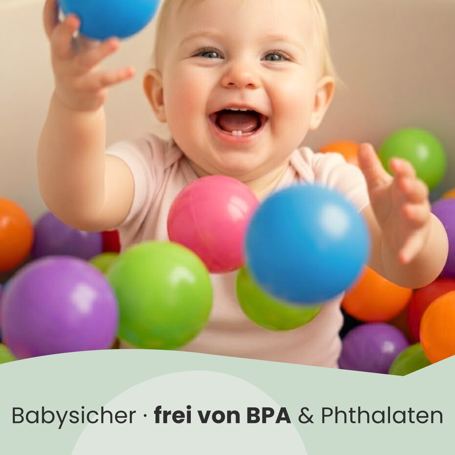 Ein Baby spielt mit bunten Bällen in einer Kugelgrube.