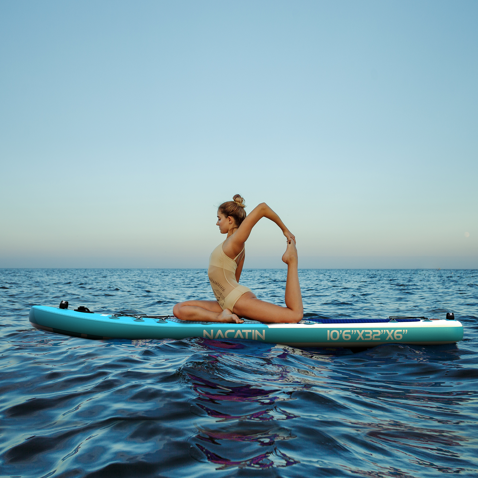 Eine Frau in einem Badeanzug macht Yoga auf einem Paddleboard auf dem Meer.