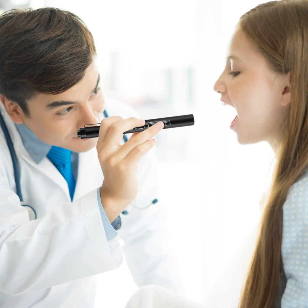 Arzt untersucht Rachen einer Patientin mit einer Taschenlampe.
