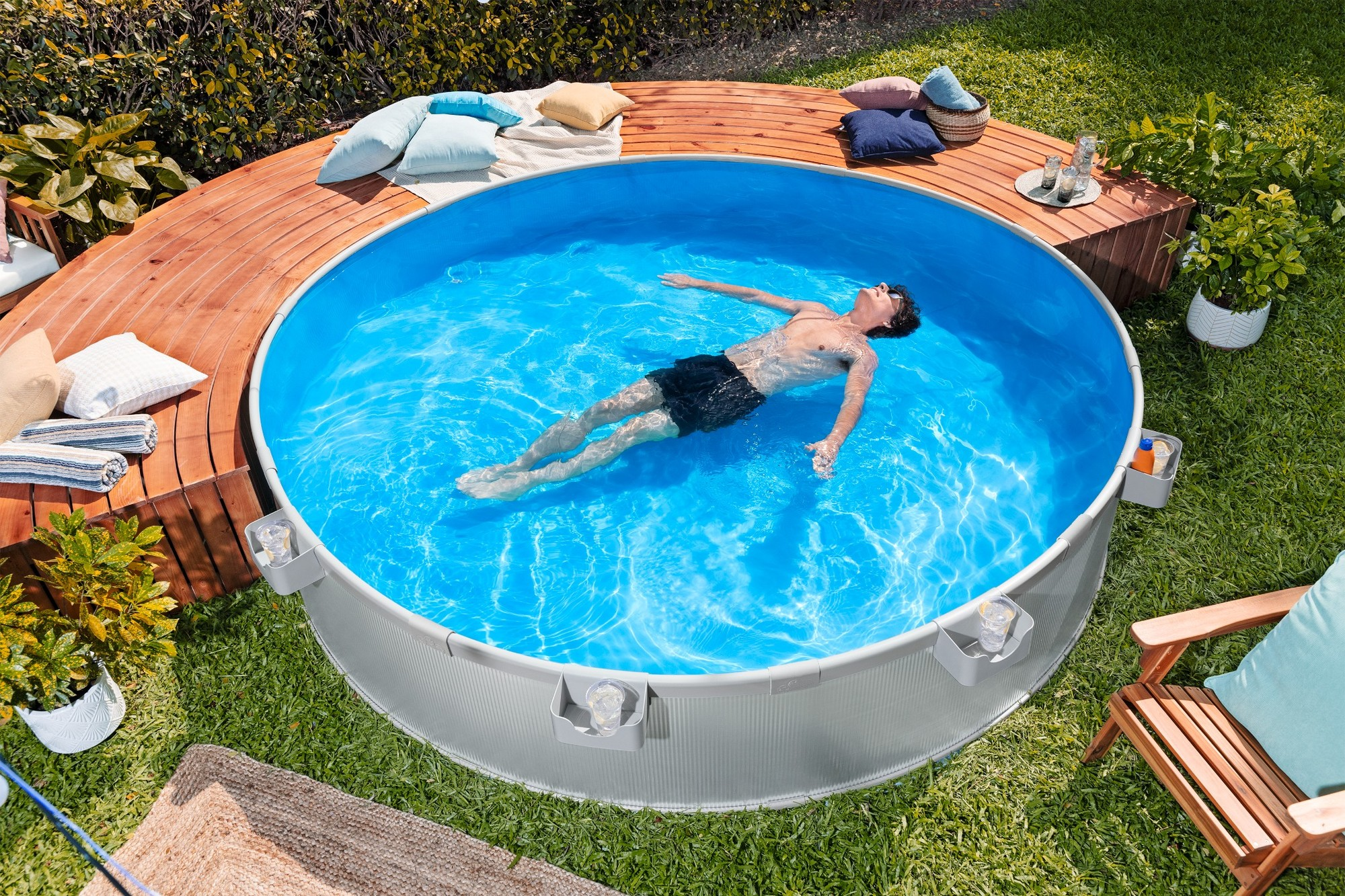 Ein Mann treibt auf dem Rücken in einem runden Pool im Garten.