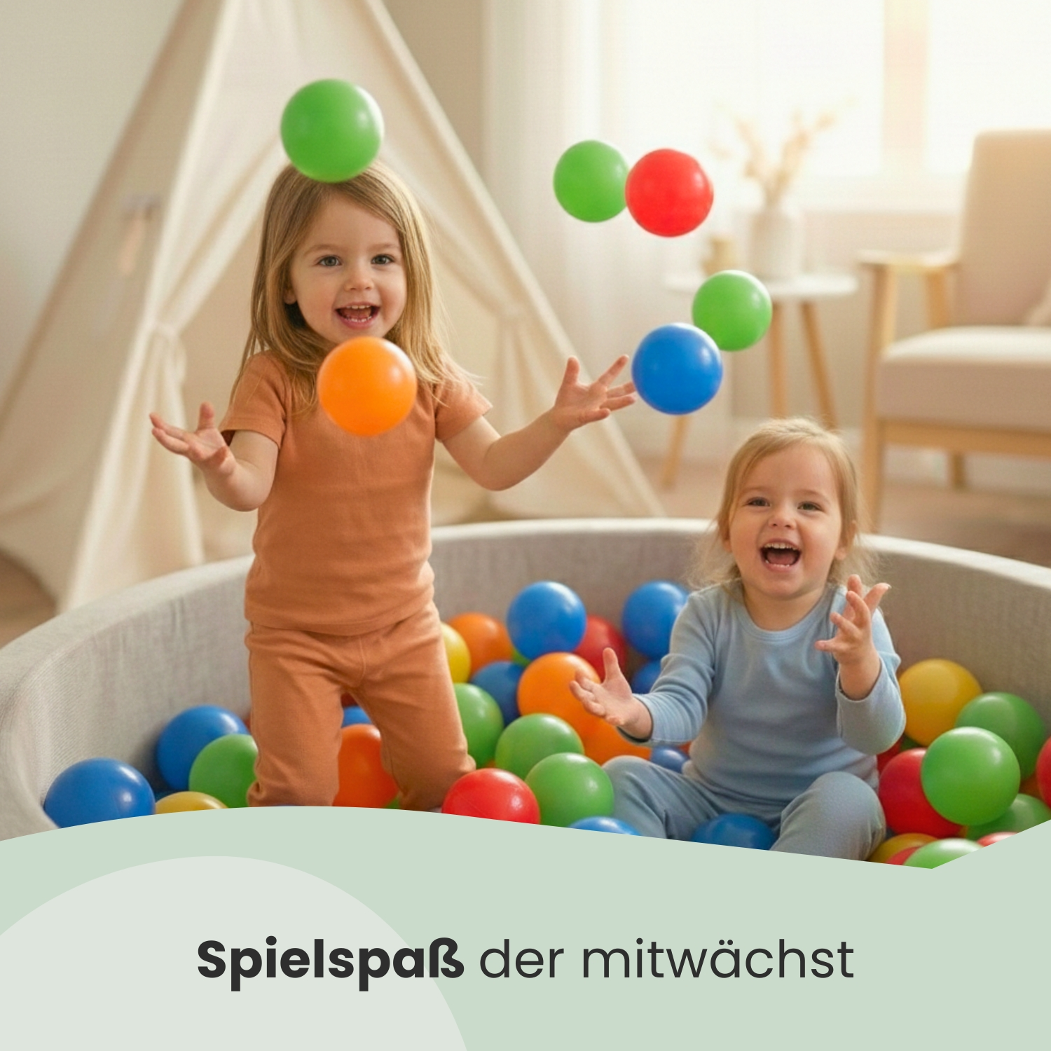 Zwei lachende Kinder spielen mit bunten Bällen in einem Bällebad.