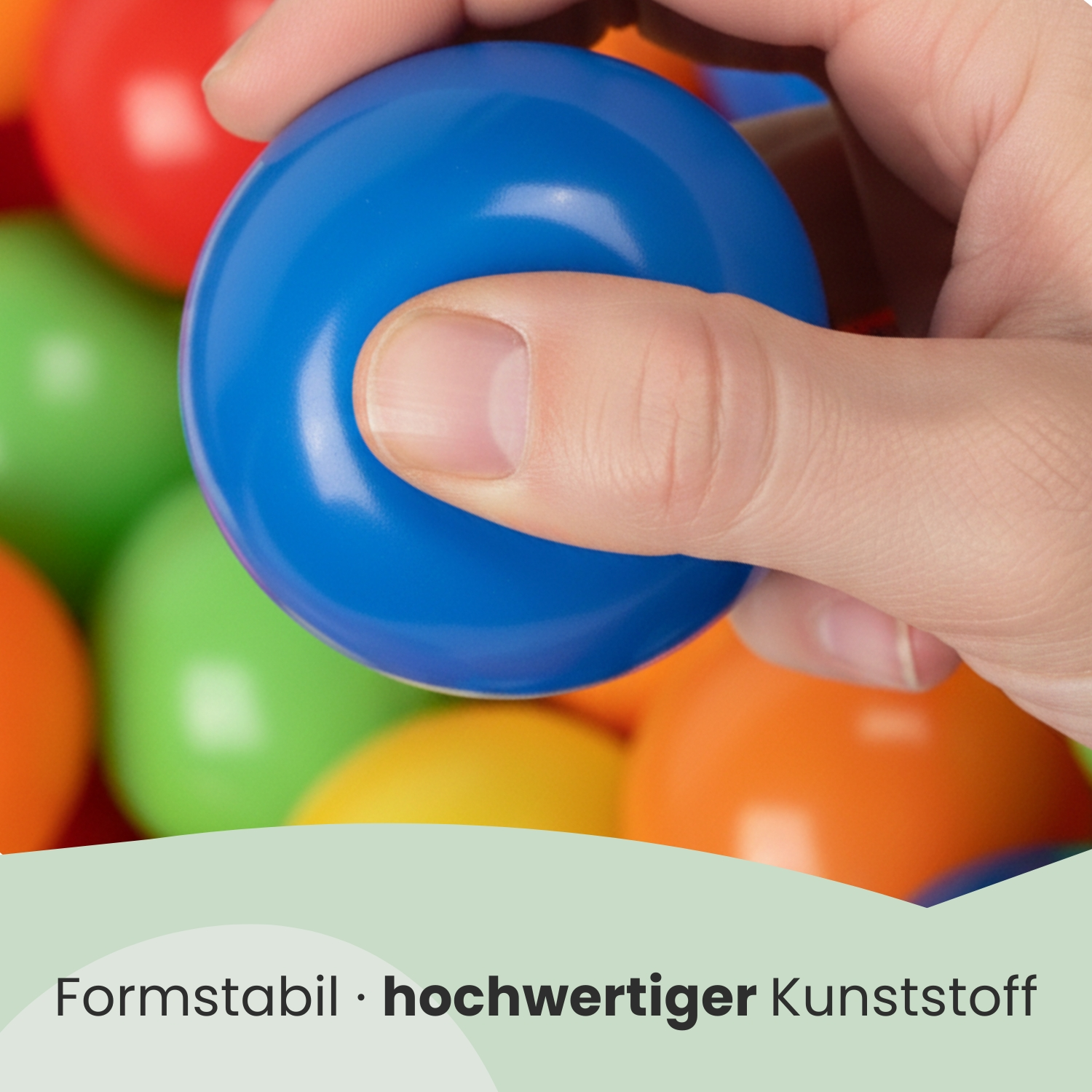 Eine Hand hält einen blauen Ball über bunte Bälle.