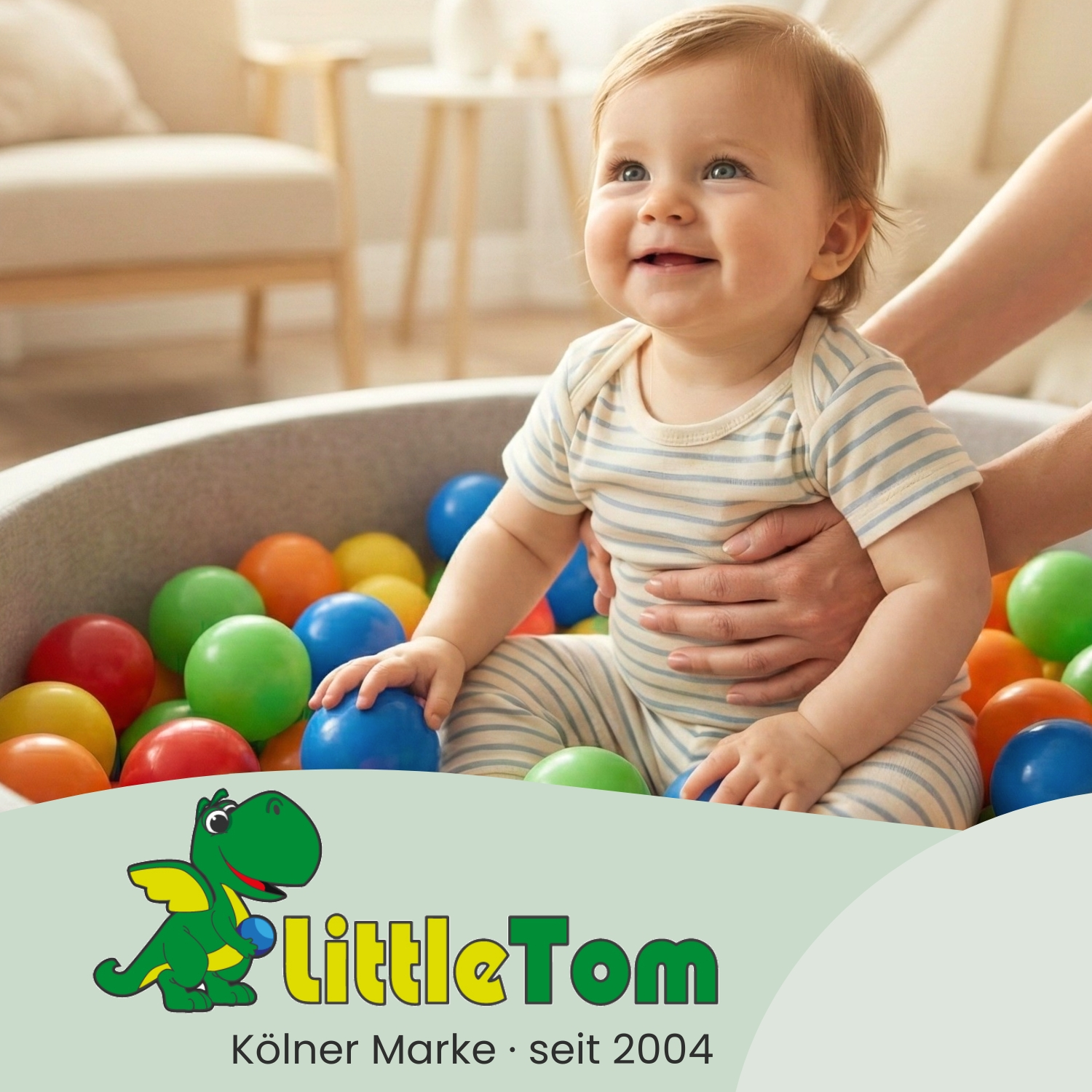 Ein Baby sitzt in einem Ballbad mit bunten Bällen. Ein Logo ist im Vordergrund.