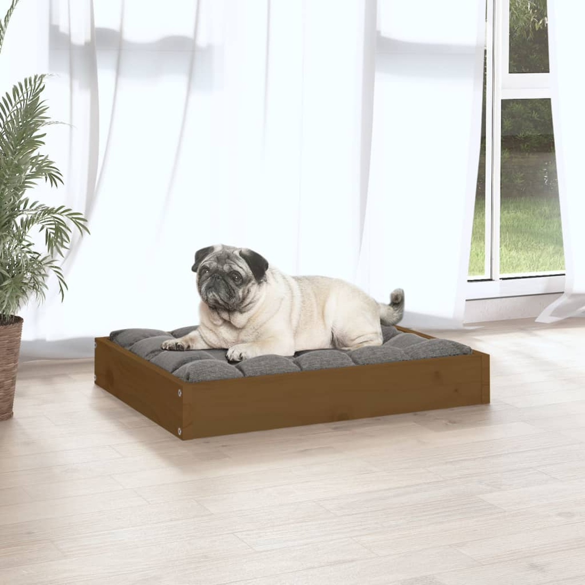 Ein Mops liegt auf einem braunen Holzbett mit grauer Polsterung vor einem Fenster.