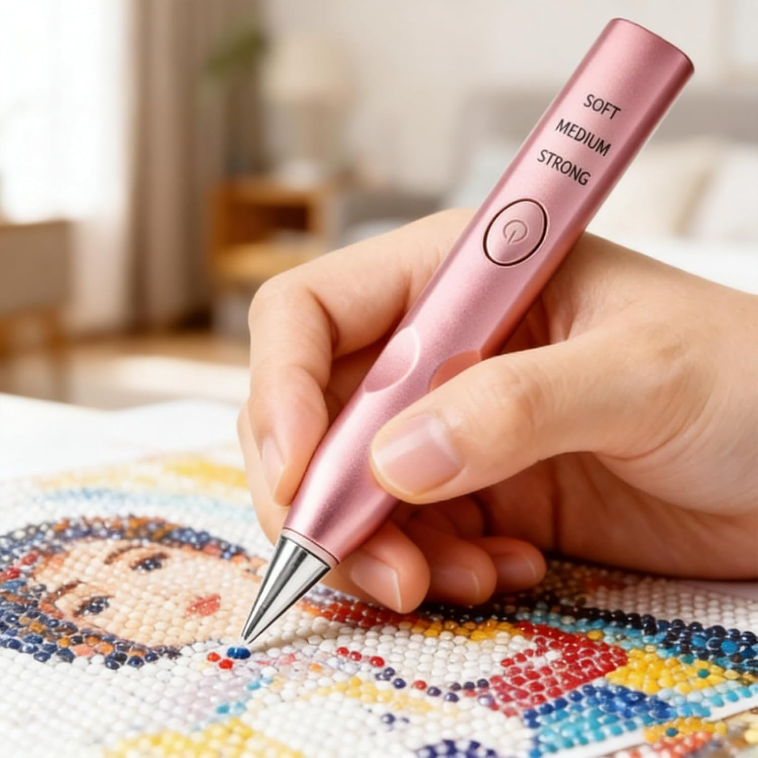 Eine Hand hält einen rosa Diamantmalstift über einem bunten Diamantkunstporträt.