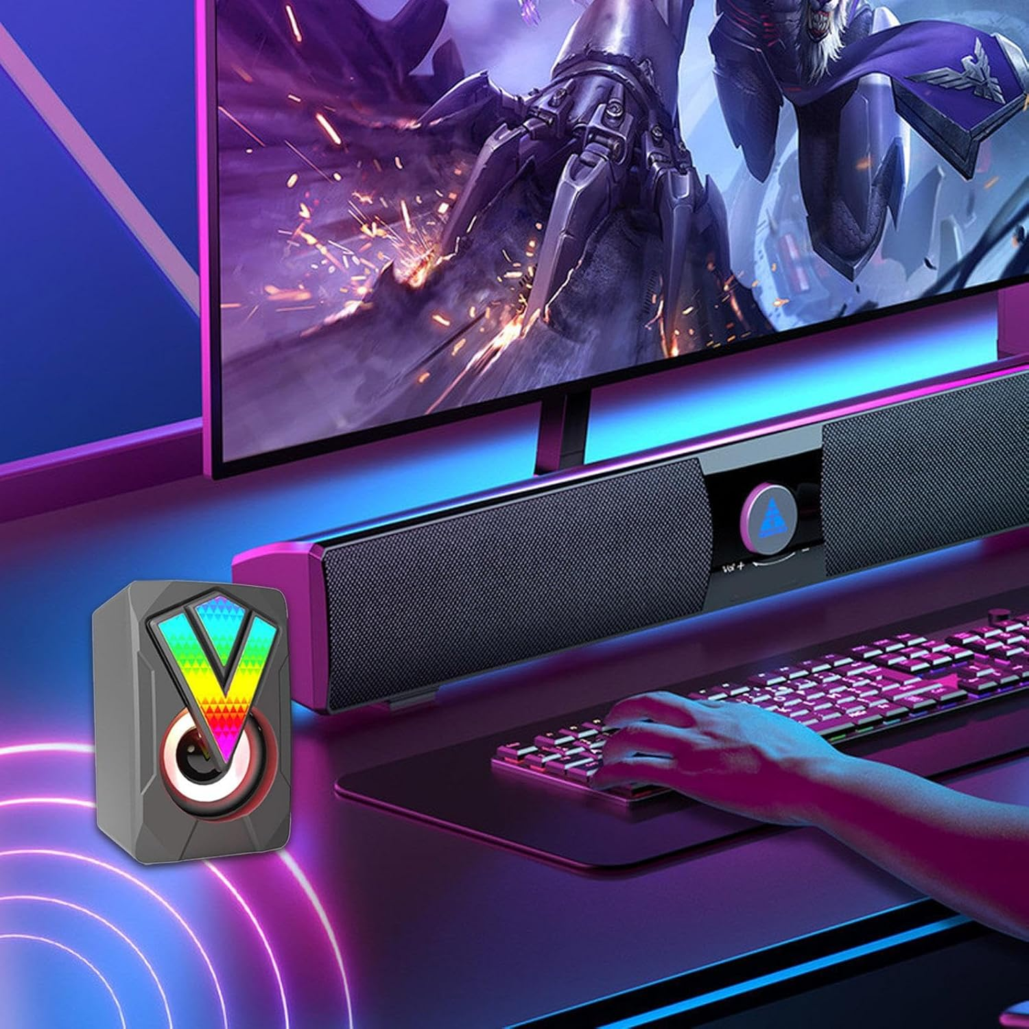 Gaming-Setup mit RGB-Lautsprecher, Soundbar, Tastatur und Bildschirm mit Spiel.