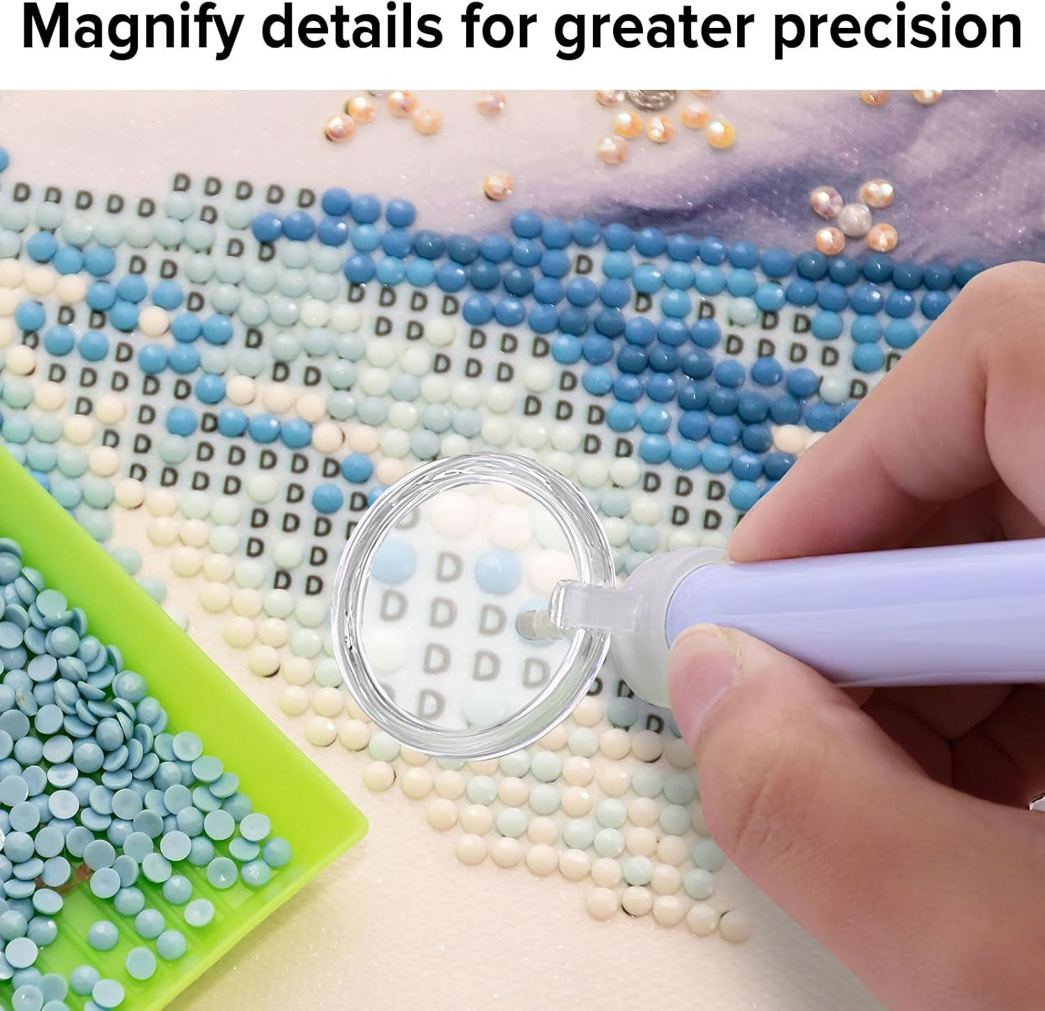 Eine Hand benutzt einen Stift, um blaue und weiße Diamanten auf einer Leinwand zu platzieren.