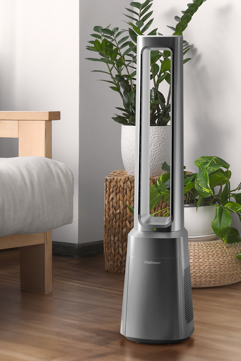 Ein schlanker Turmventilator steht neben einem Bett und Pflanzen.