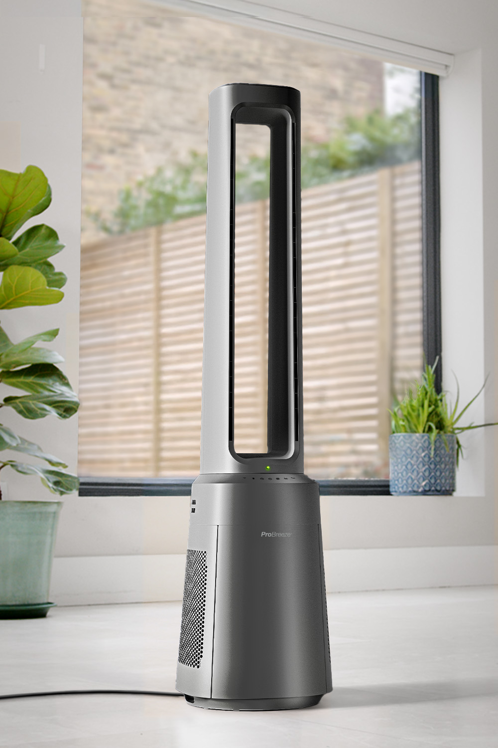 Ein schlanker, grauer Turmventilator mit grüner LED-Anzeige steht auf einem weißen Boden.