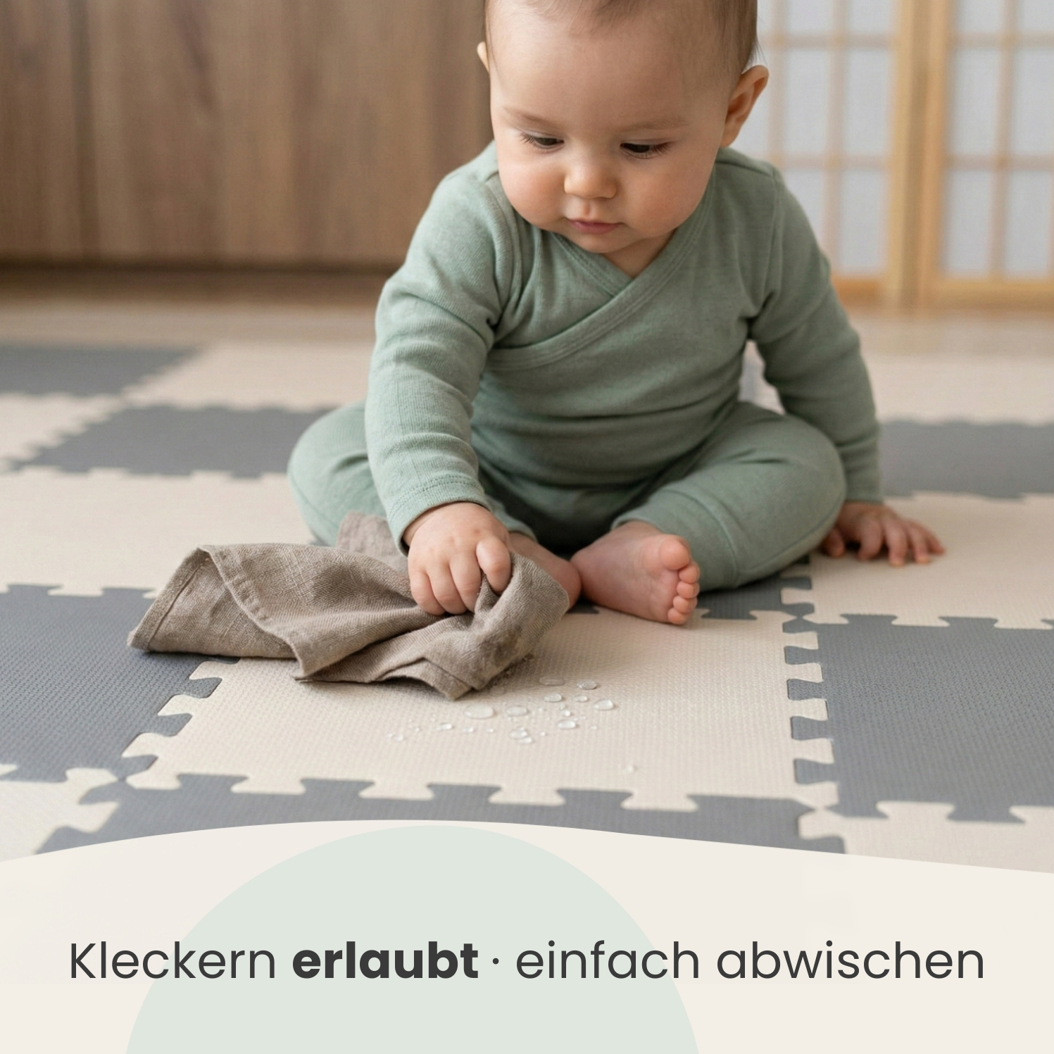 Baby wischt mit Tuch über Wasserflecken auf dem Boden.