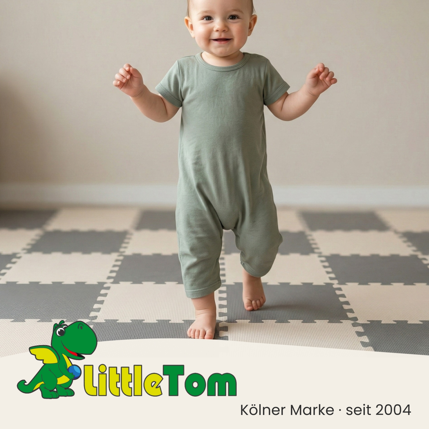 Ein Baby in einem hellgrünen Strampler auf einem karierten Boden.