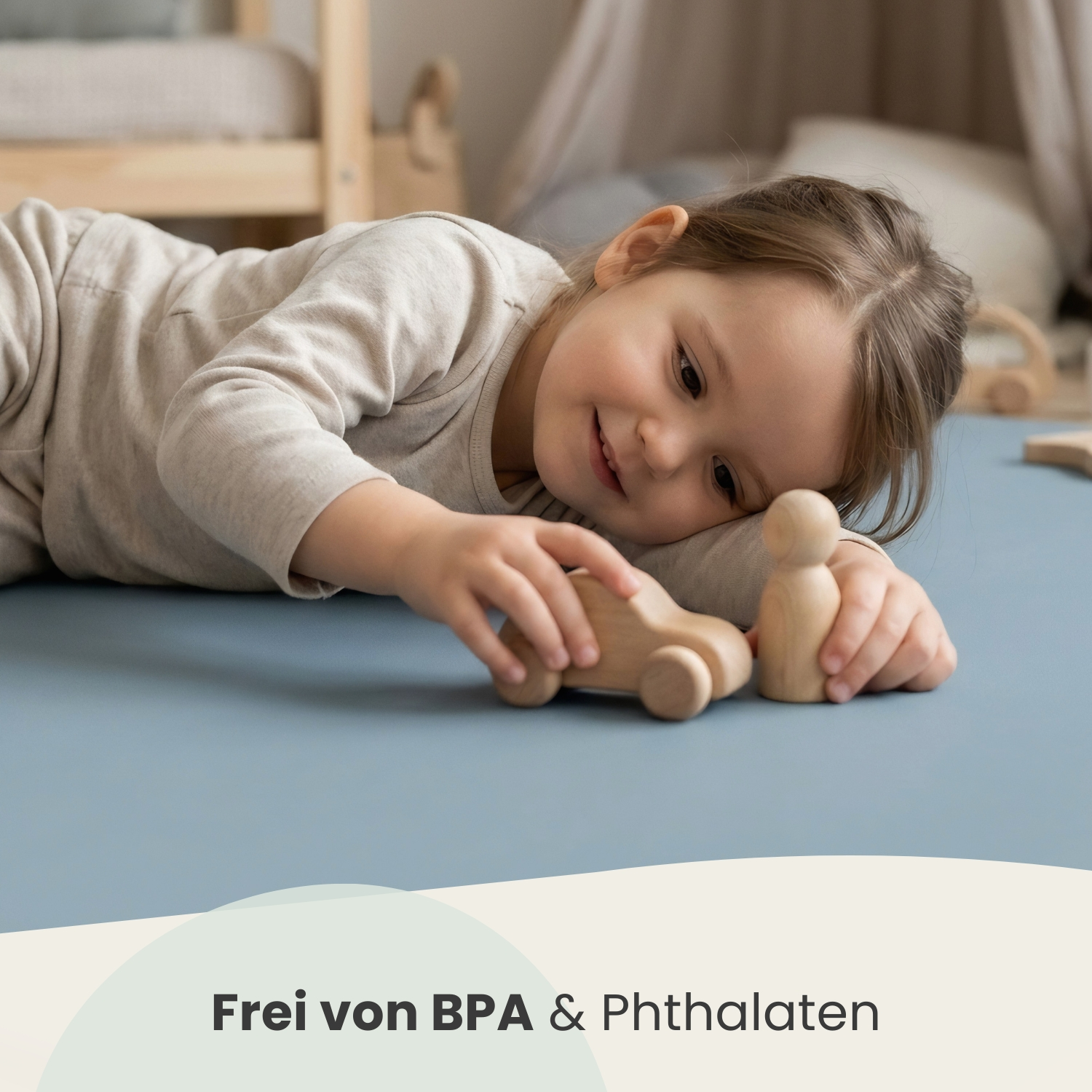 Ein kleines Mädchen spielt mit Holzspielzeugautos auf einem blauen Teppich.