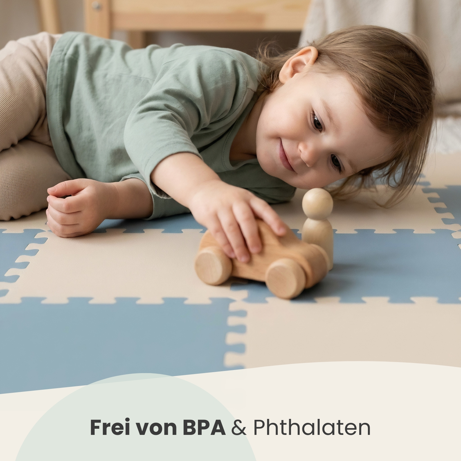 Ein Kleinkind spielt auf einer Matte mit einem Holzauto und einer Holzfigur.