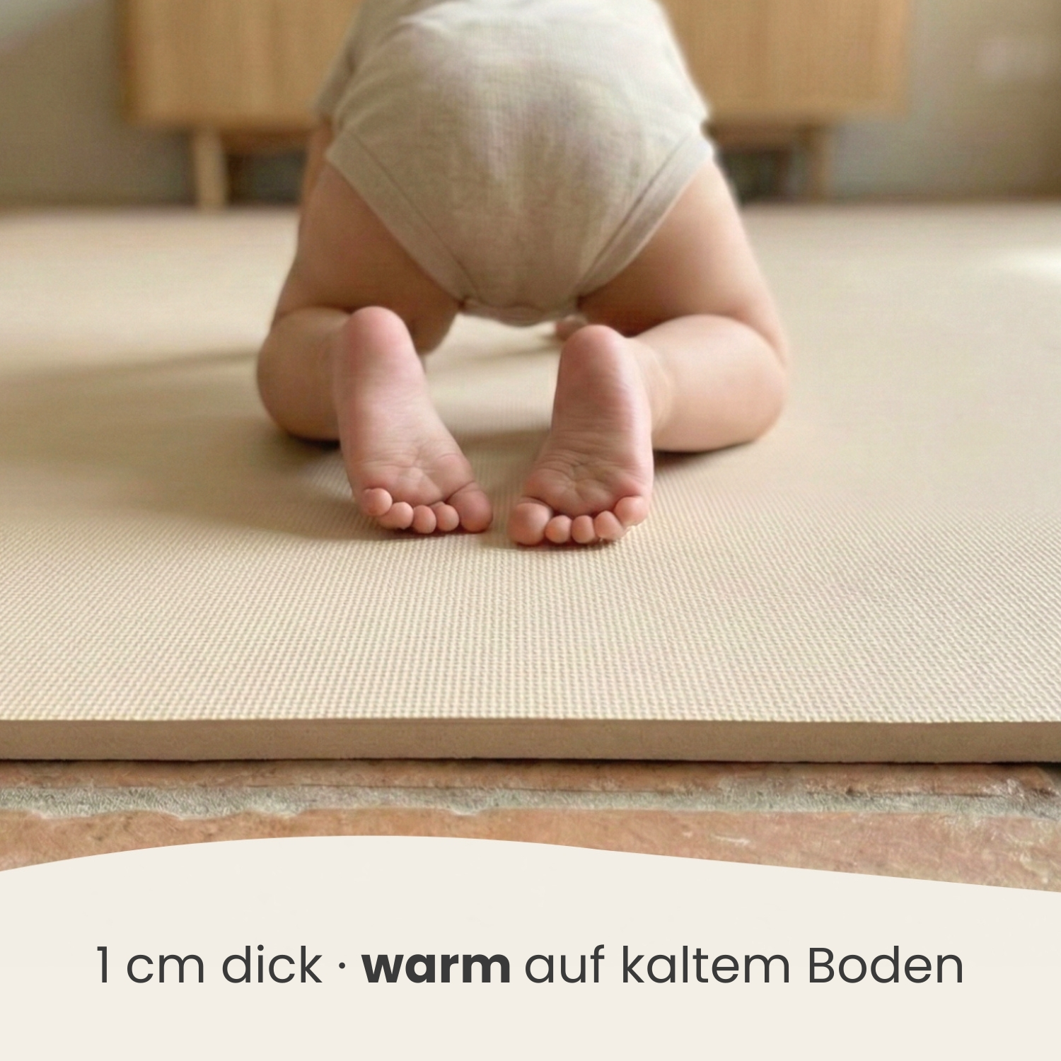 Ein Baby krabbelt auf einer dicken, warmen Matte auf dem Boden.