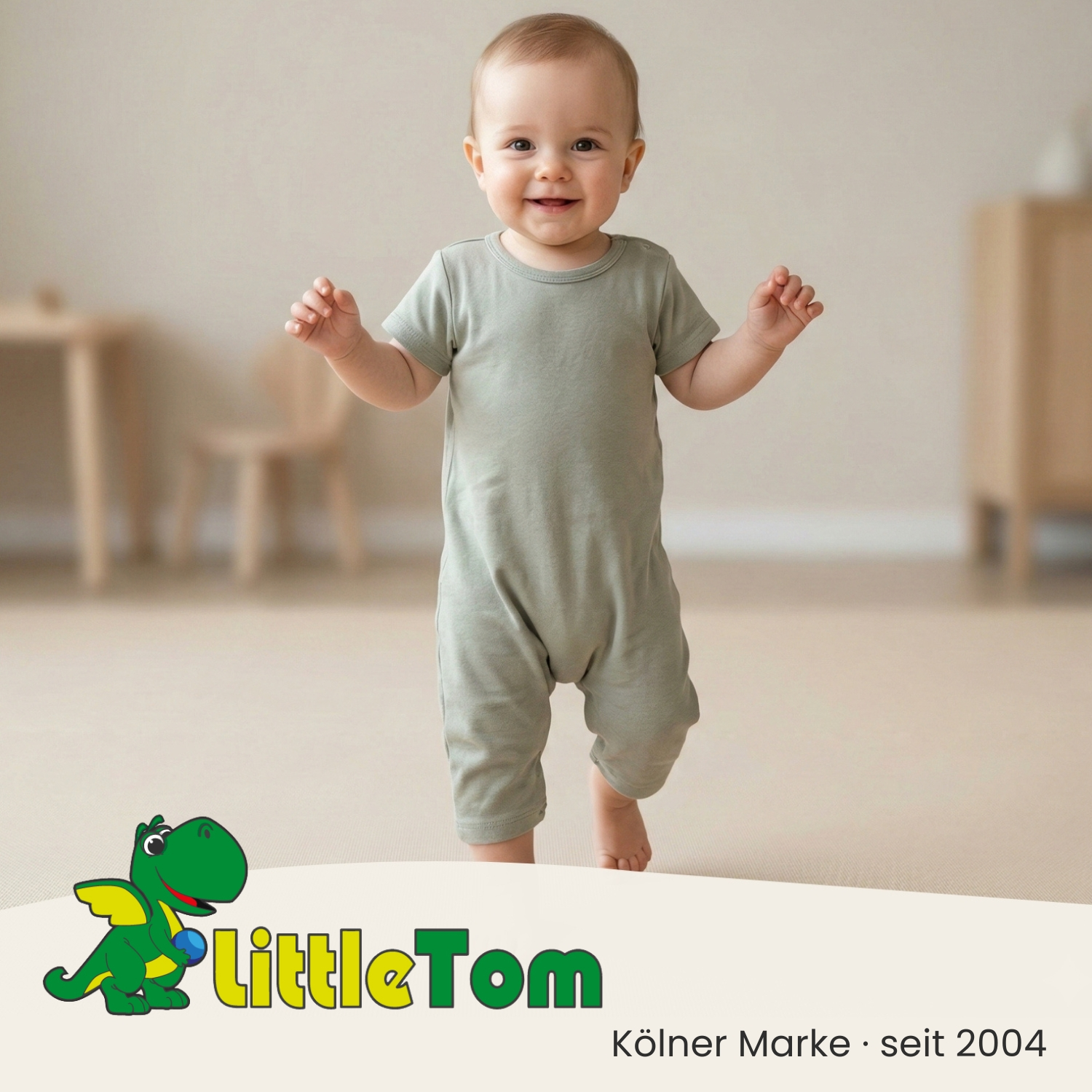 Ein lächelndes Baby in einem grauen Strampler steht aufrecht. Im Vordergrund ein Dino-Logo mit Schriftzug.