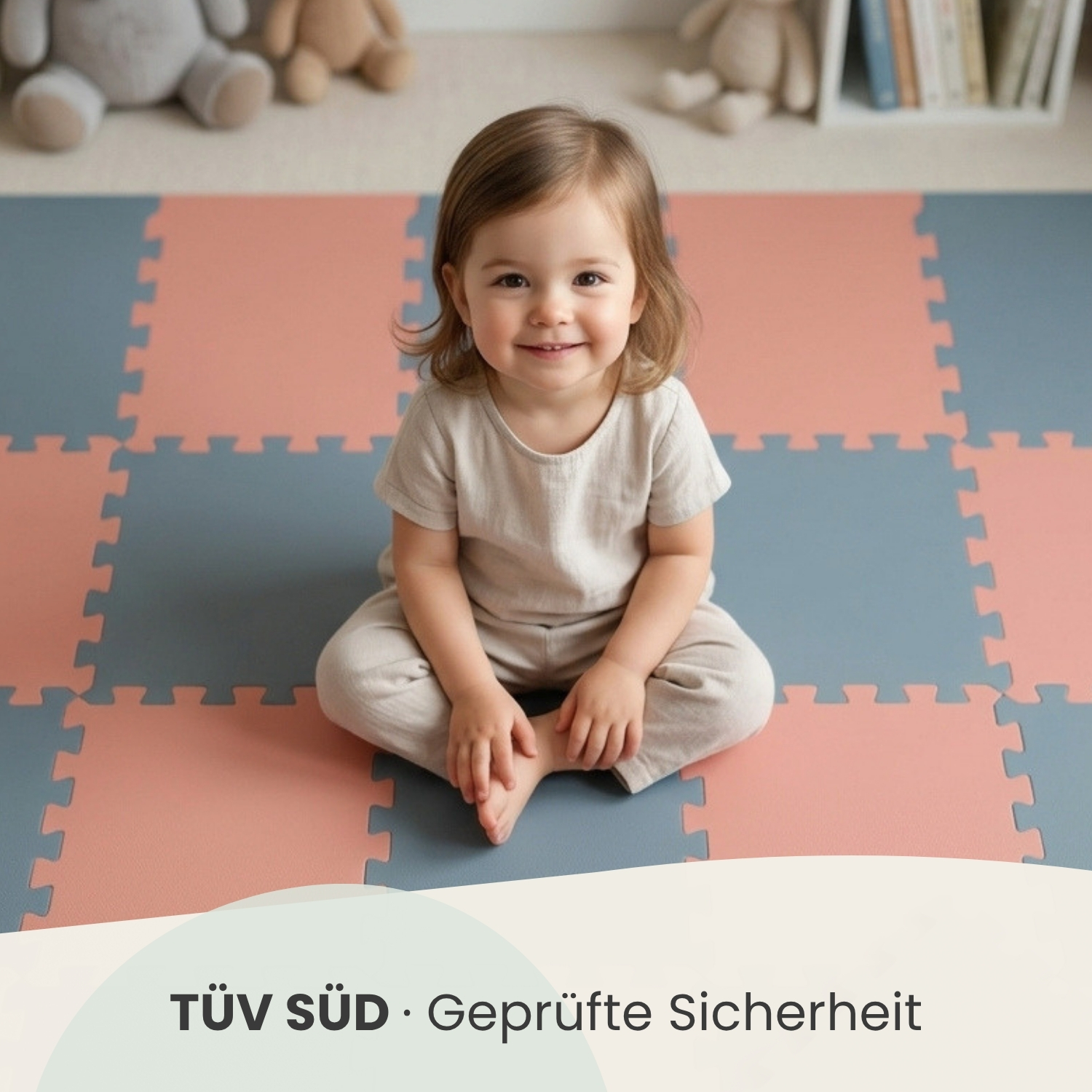 Ein lächelndes Kleinkind sitzt auf einer gepolsterten Spielmatte mit Pfirsich- und Blautönen.