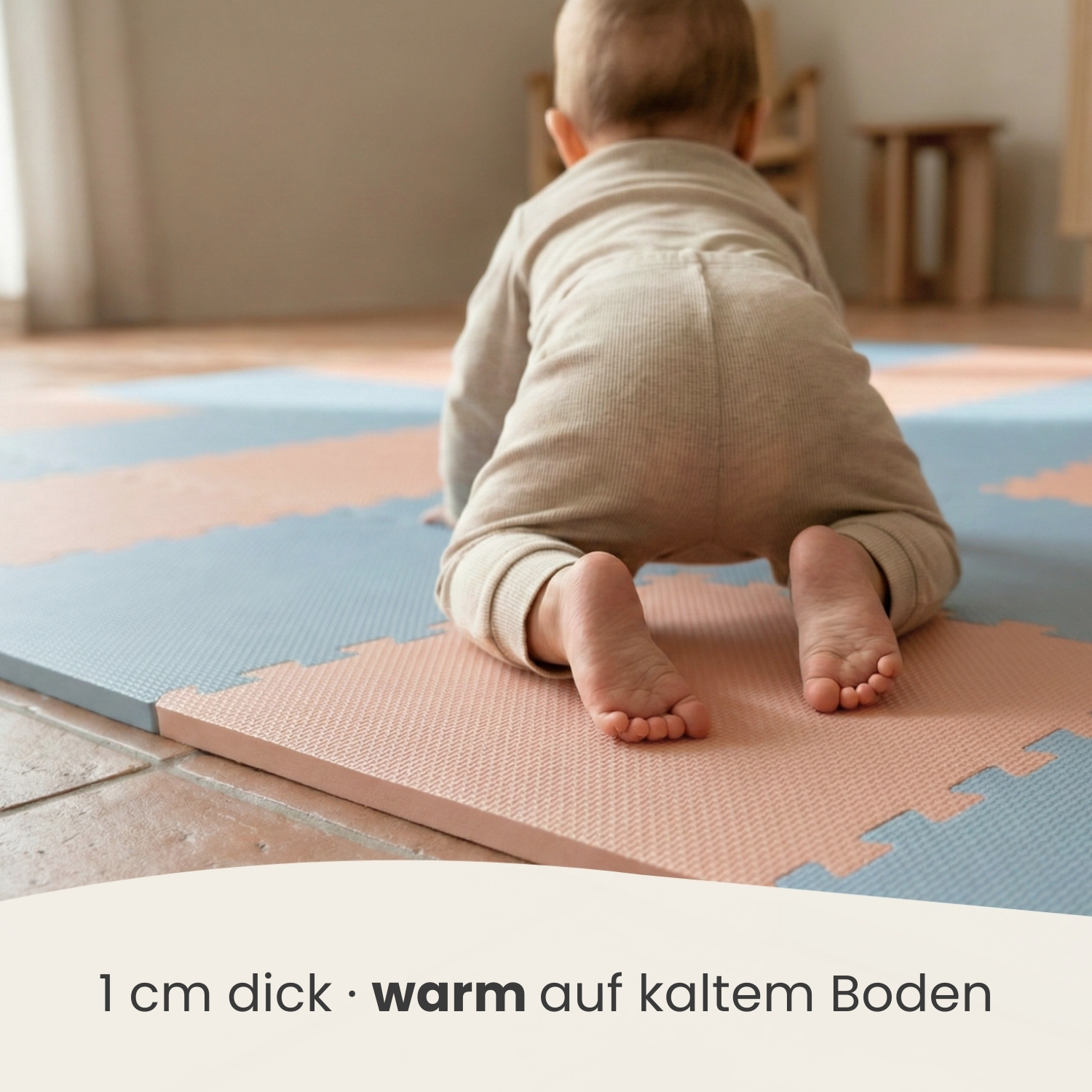 Baby krabbelt auf einer weichen Matte in Rosa und Blau.