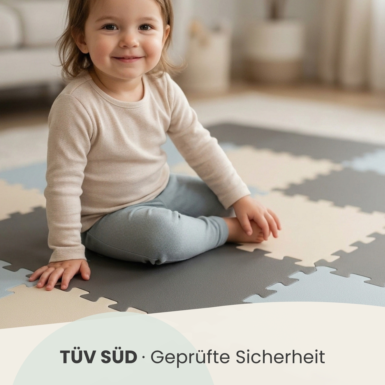 Ein Kleinkind sitzt lachend auf einer bunten Matte. Der Hintergrund ist unscharf.