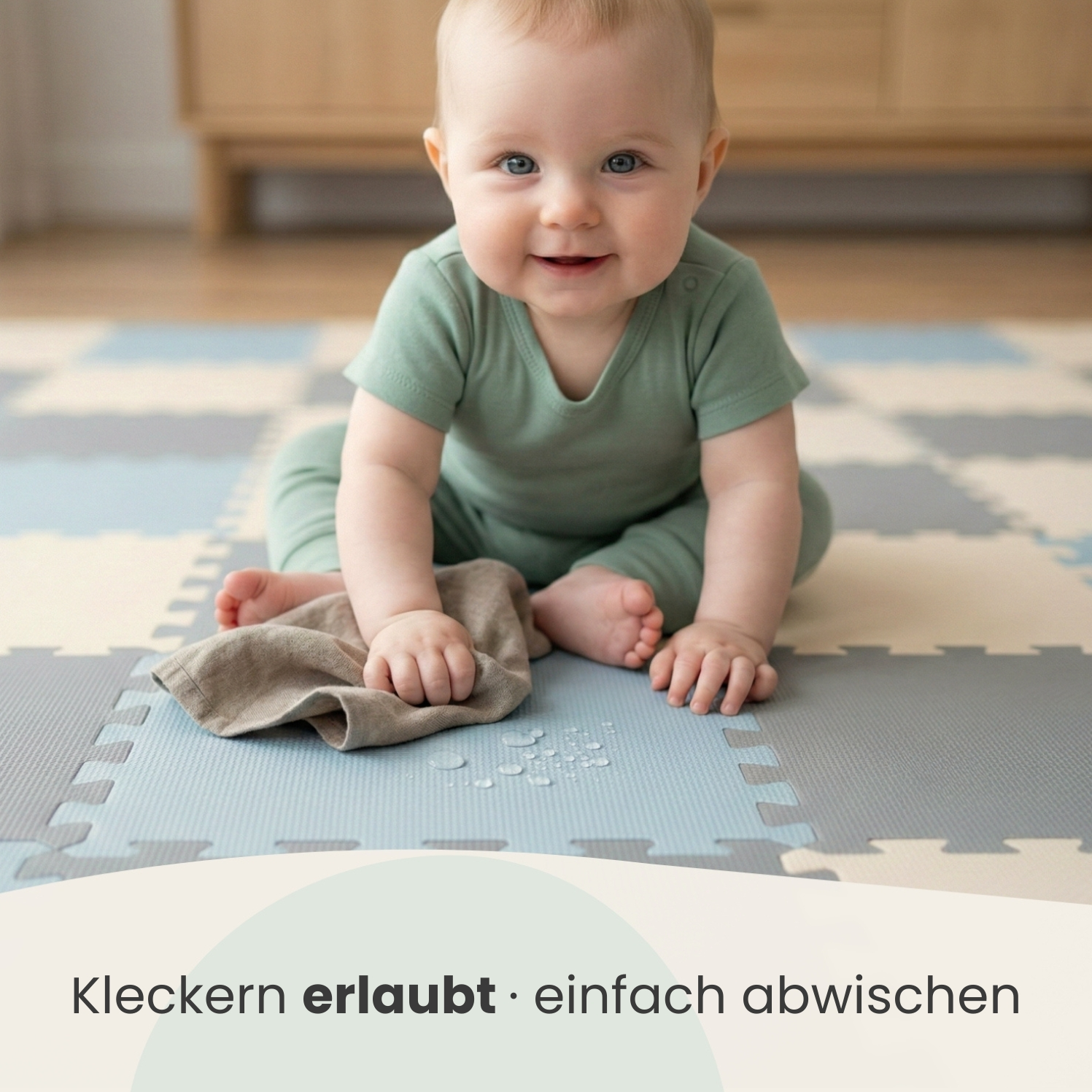 Ein Baby sitzt auf einer Puzzlematte mit einem Tuch in der Hand.