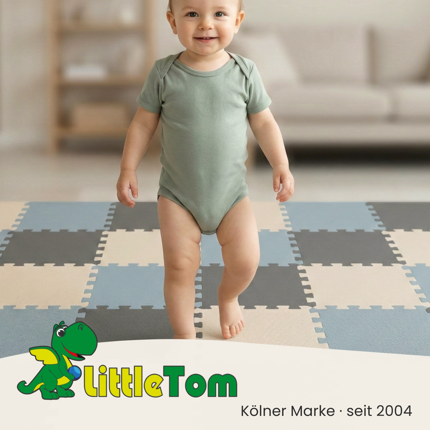 Ein Baby in einem hellgrünen Body steht auf einer Puzzlematte. Ein Drache mit Logo.