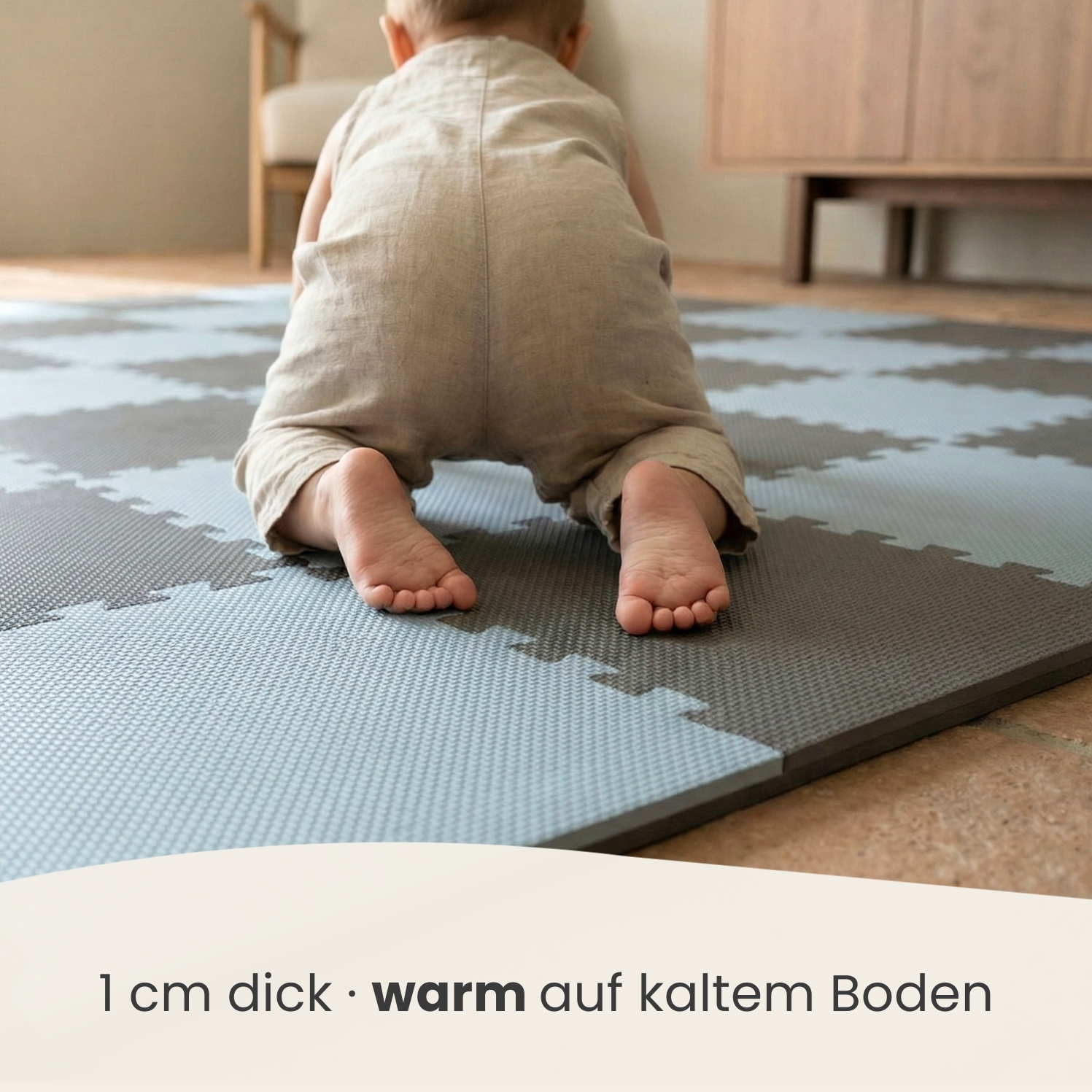 Ein Baby krabbelt auf einer grauen und blauen Puzzlematte. Nahaufnahme der Füße.