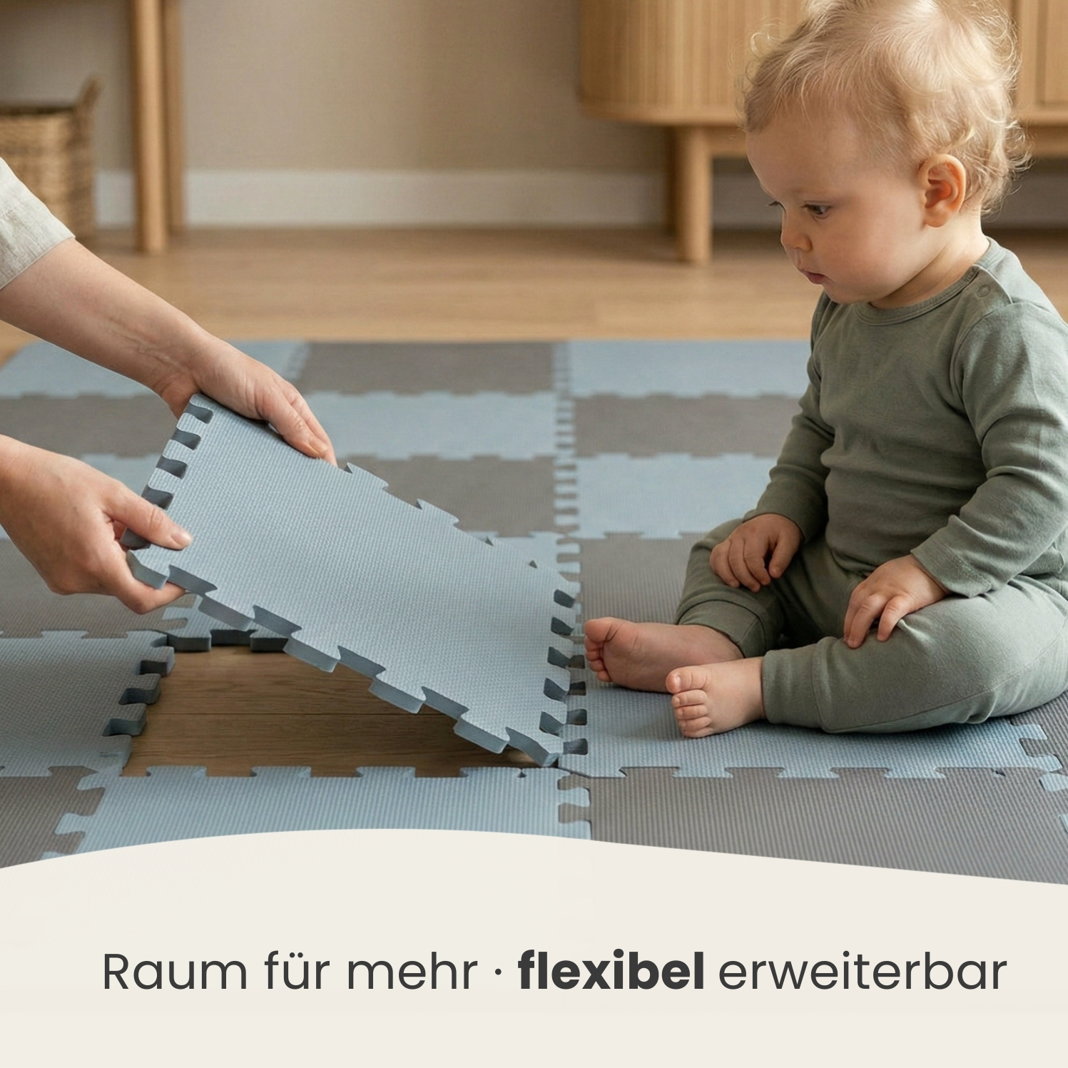 Ein Baby sitzt auf einer grauen und blauen Spielmatte, während Hände eine weitere Matte hinzufügen.