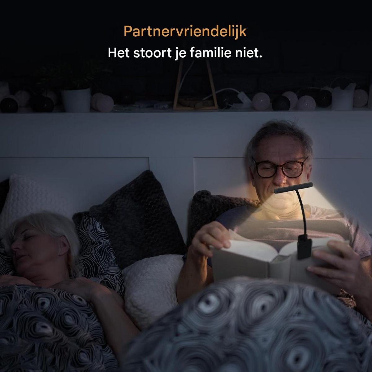 Ein Mann liest im Bett bei Nacht, eine Frau schläft daneben.
