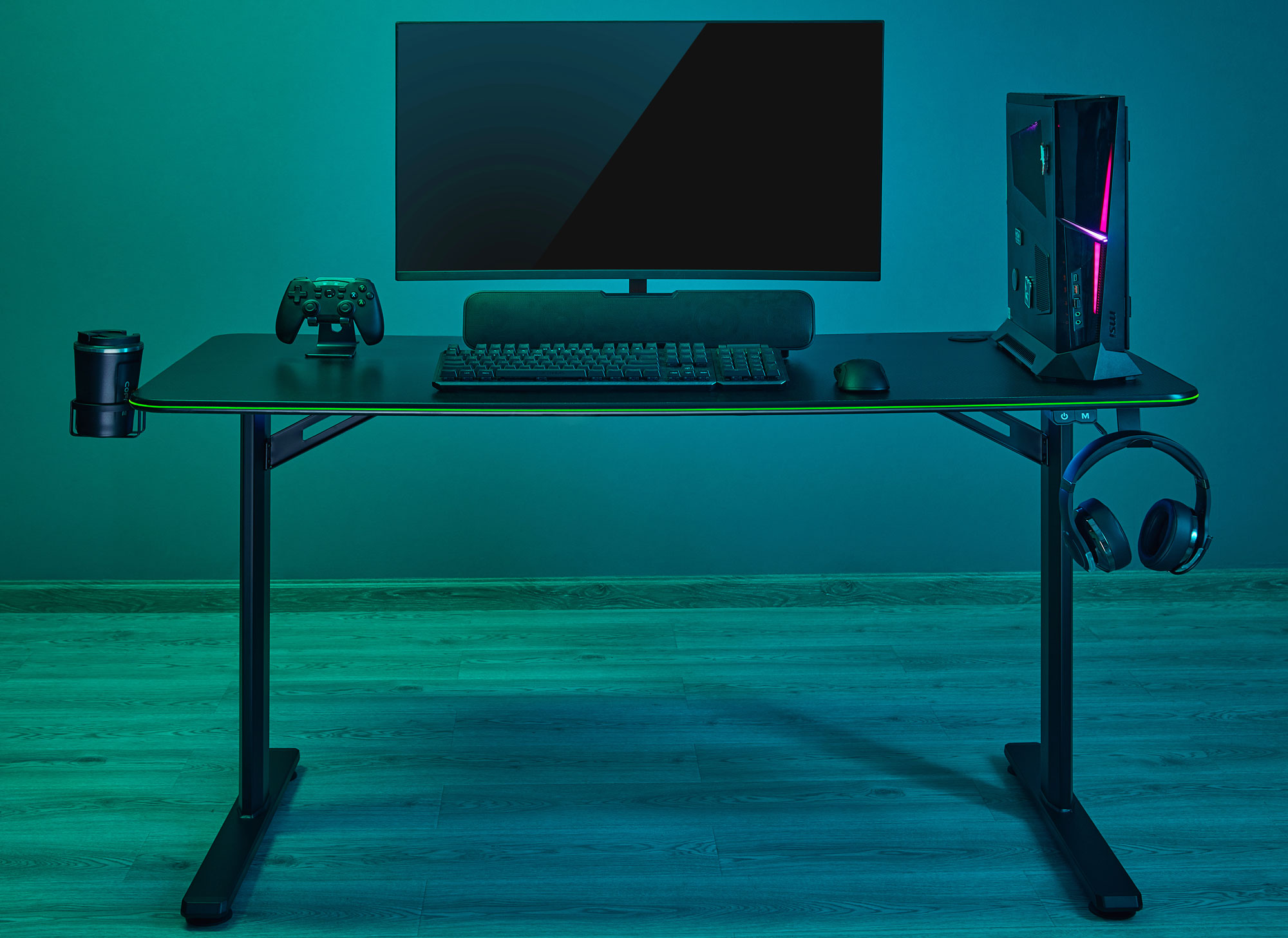 Ein Gaming-Schreibtisch mit Monitor, PC, Tastatur, Maus, Controller und Kopfhörern.