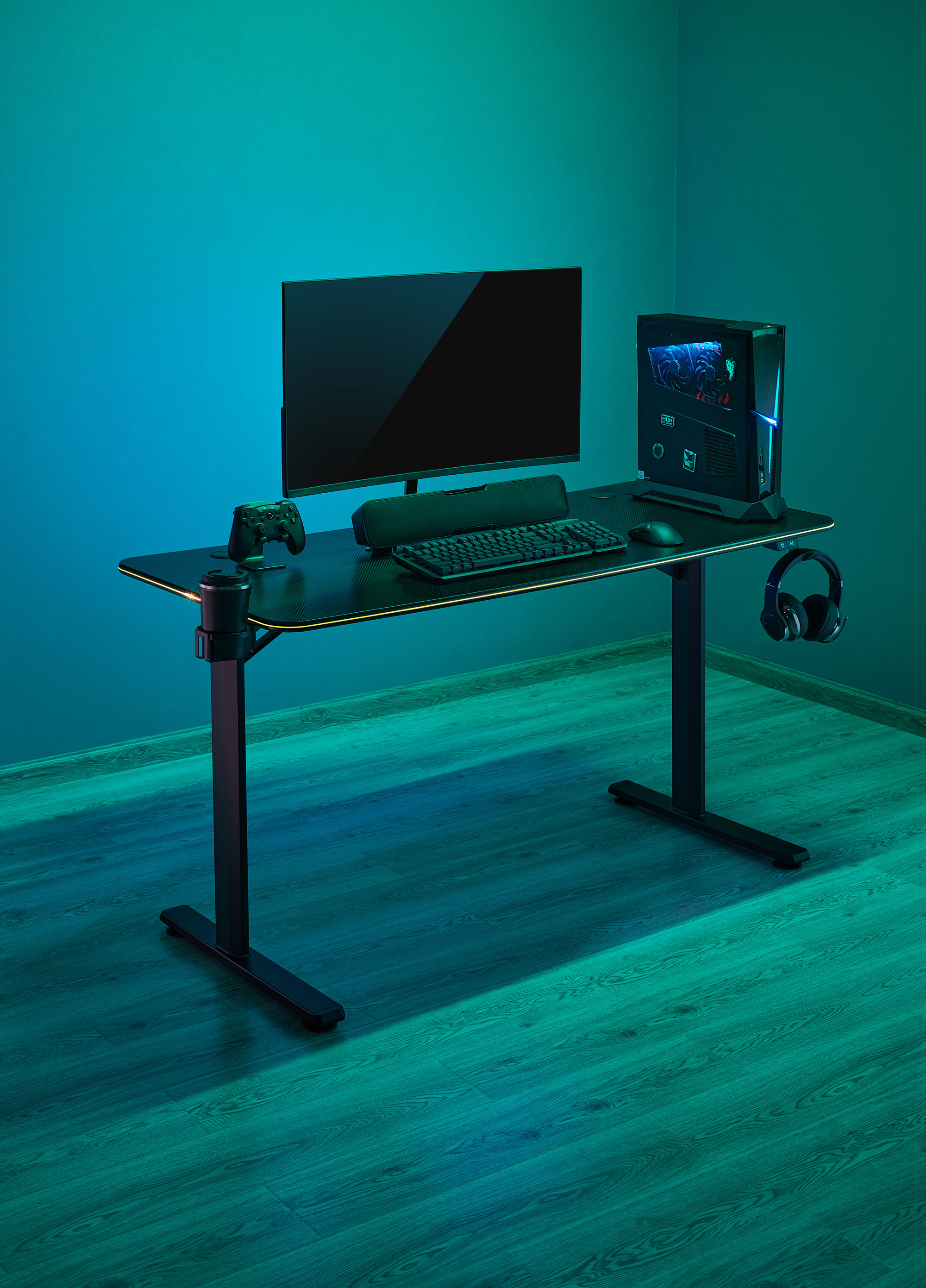 Ein Gaming-Schreibtisch mit Monitor, Tastatur, Maus, PC und Kopfhörern.