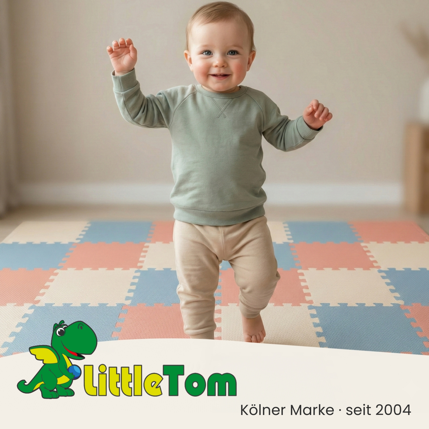 Ein Baby in einem hellgrünen Pullover steht auf einer bunten Spielmatte.