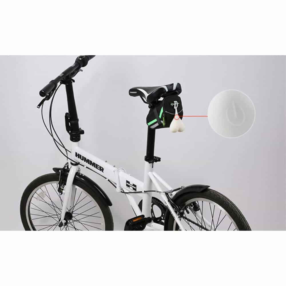 Weißes faltbares Hummer-Fahrrad mit schwarzer Satteltasche und weißen Scherz-Bällen.