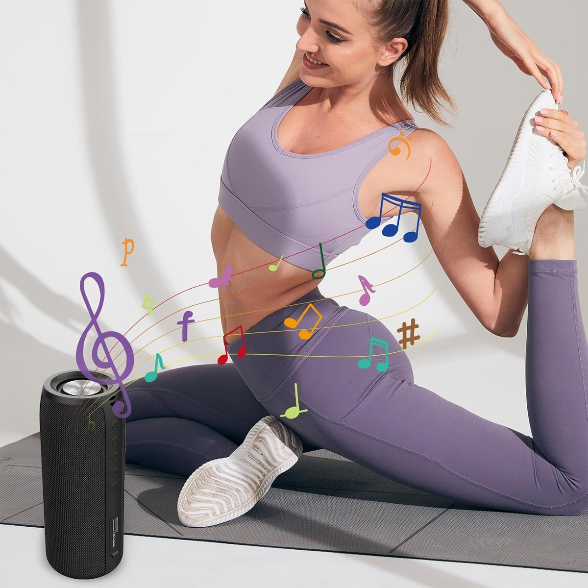 Eine Frau macht Yoga auf einer Matte, daneben ein Lautsprecher mit Noten.