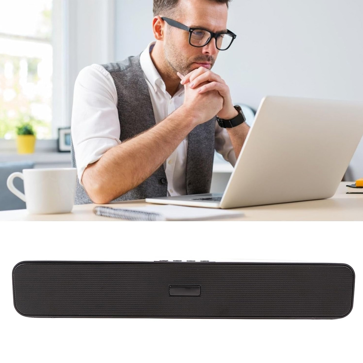 Ein Mann in Brille und Weste sitzt vor einem Laptop. Daneben eine schwarze Soundbar.