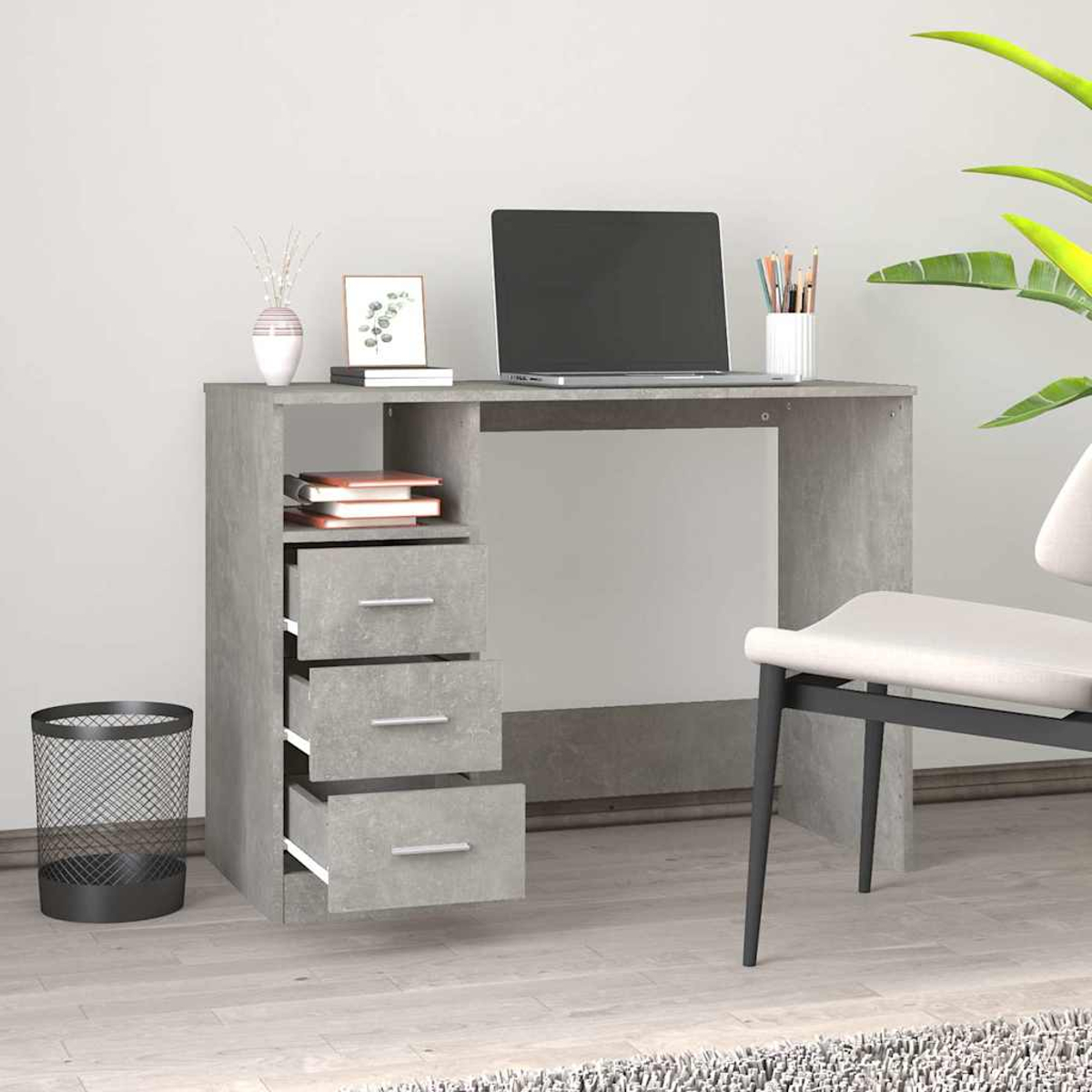 Grauer Schreibtisch mit Laptop, Büchern, Vase und einem Papierkorb daneben.