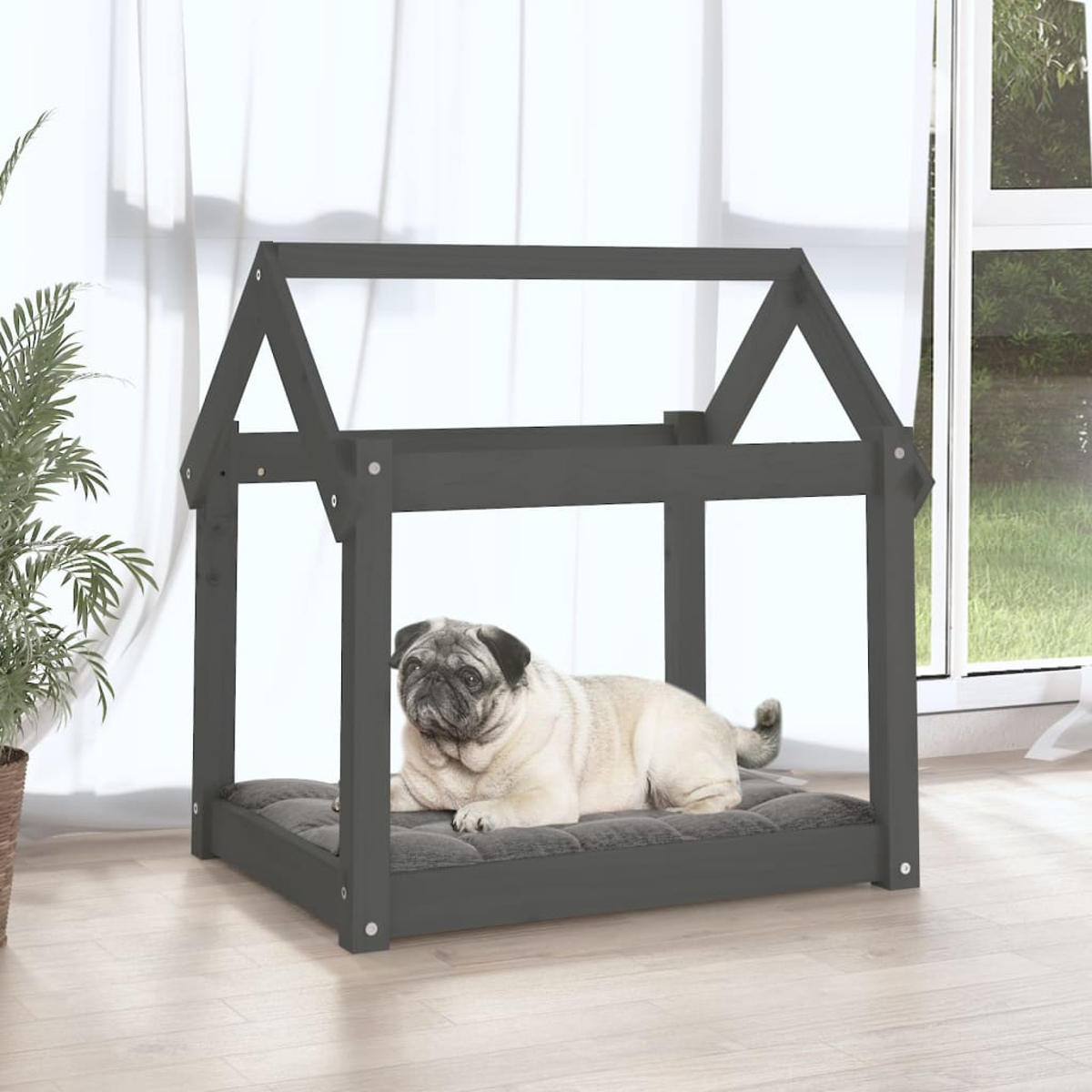 Ein Mops liegt auf einem grauen Kissen in einem dunklen Holzhundhaus mit Dach.