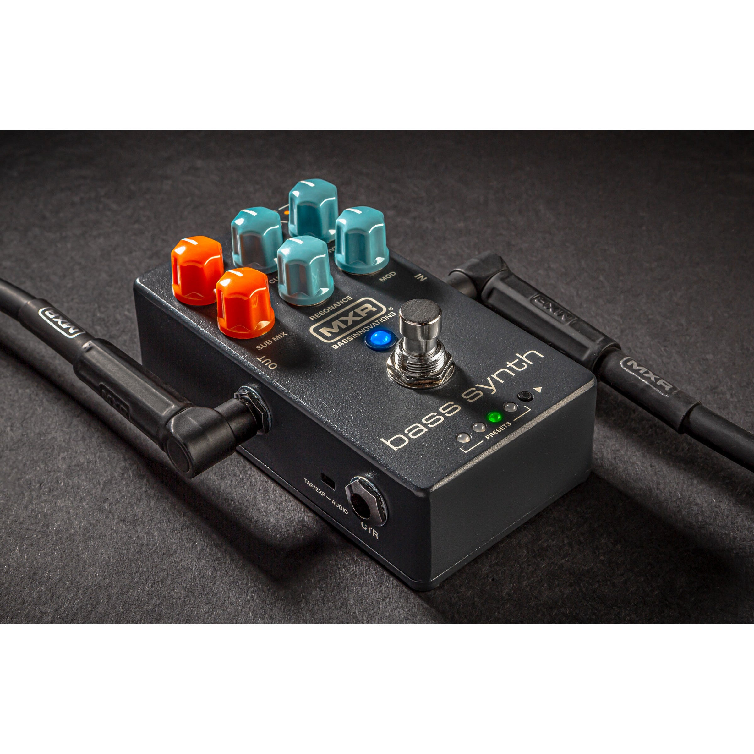 Een zwart MXR Bass Synth effectpedaal met blauwe en oranje knoppen, verbonden met kabels.