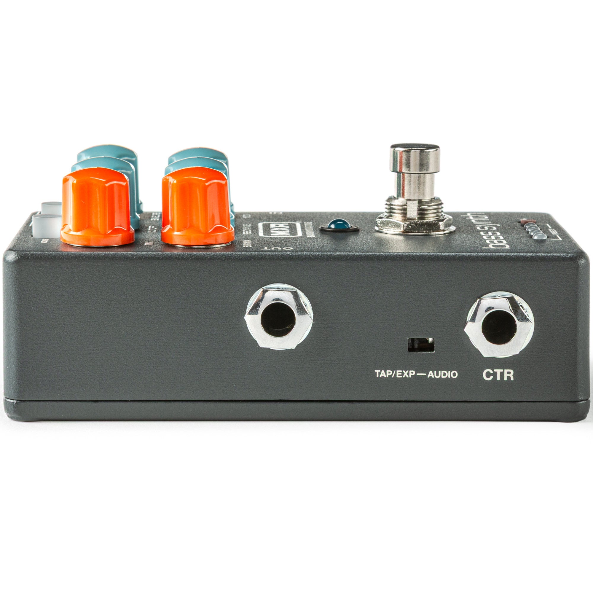 Close-up van een grijs bas synth effectpedaal met oranje en turquoise knoppen en metalen voetschakelaar.