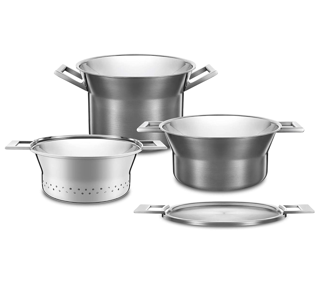 Cztery błyszczące metalowe garnki i płaski talerz do serwowania z uchwytami.