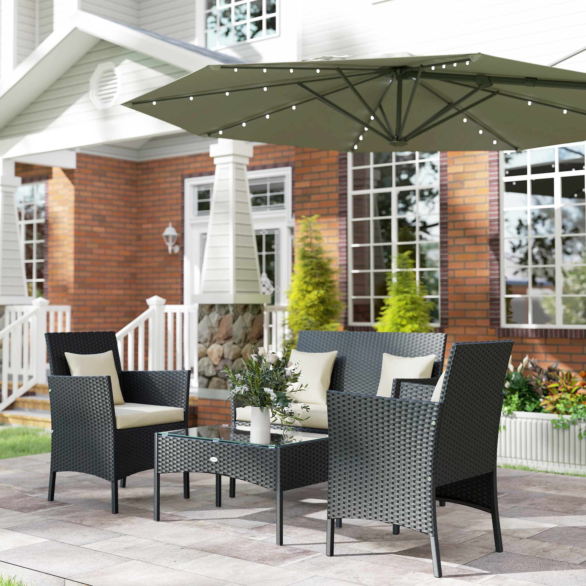 Set de patio exterior con sillas, sofá, mesa y sombrilla con luces.